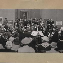Concert de trois violons et une contrebasse dans une salle d'exposition